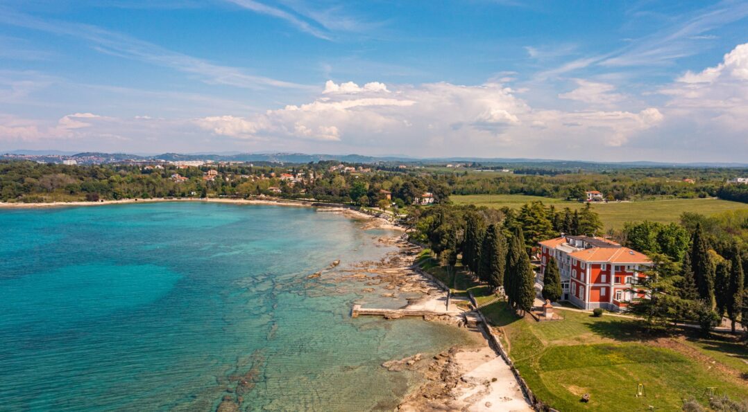 Zračna fotografija Vile Valdepian uz obalu s tirkiznim morem i zelenim krajolikom u Istri